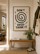 Don’t Overthink It poster in houten lijst aan de muur in een lichte moderne hal