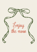 Enjoy the Now – Groene Lintstrik – Een sierlijke groene lintstrik rondom de rode woorden Enjoy the now op crème.
