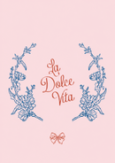 La Dolce Vita – Blauw Bloemenkader en Rode Strik – Een blauw botanisch bloemenkader rond rode La Dolce Vita letters, met een kleine rode strik op roze.
