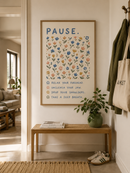 Pause bloemenposter in houten lijst aan de muur in een lichte Scandinavische hal