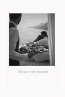 Zwart-wit poster van butler met ontbijt op bed en zeezicht met quote “Elevate every moment”