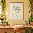 Don’t Forget to Have a Good Time – Groene Bloemenvaas in een lichte hobbykamer met zachtgele muur, houten bureau en verse bloemen
