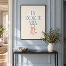 La Dolce Vita – Rode Sleutelbos in een elegante hal met lichtblauwe panelen, smalle zwarte console en keramieken schaal
