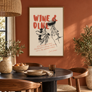 Wine & Dine – Hand met Wijnglas en Olijftak in een eetkamer met terracotta wand en zwarte ronde tafel