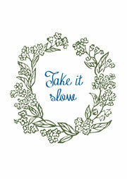 Take It Slow – Groene Bloemenkrans – Een groene bloemenkrans rond blauwe handgeschreven woorden op wit.