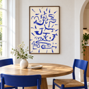 Paul Klee - Kriechendes und Baumendes (Creeper and Climber) (1937) in een witte eethoek met blauwe stoelen en een ronde eiken tafel