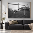 Historische foto van keeper Bals tijdens PSV tegen Heracles in een eiken lijst boven een grijze bank.