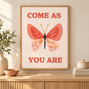 Come As You Are vlinder quote poster in houten lijst boven een eiken kast in een warm interieur