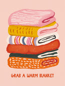 Stapel dekens in roze geel wit oranje en groen met tekst Grab a Warm Blanket op perzik