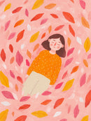 Een vrouw in een oranje trui ligt met gesloten ogen tussen kleurrijke herfstbladeren op een roze achtergrond.