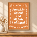 Pumpkin Spiced & Slightly Unhinged in een houten lijst boven een eiken kast in een warm beige interieur
