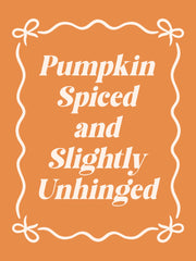 De tekst ‘Pumpkin Spiced and Slightly Unhinged’ staat in crème op oranje, omringd door een golvend kader met strikjes.