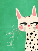 Een crèmekleurige kat met zwarte vlekken en roze details op groen, met de tekst cool cat.