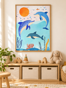 Drie Dolfijnen en Oranje Zon in een houten lijst boven een speelgoedkast in een lichte kinderkamer