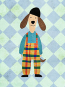 Een hond met lange bruine oren, een zwarte muts en een kleurrijke geruite tuinbroek tegen een blauw-mintgroen ruitpatroon.