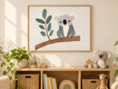Koala op een Eucalyptustak in een houten lijst boven een speelgoedkast in een lichte kinderkamer