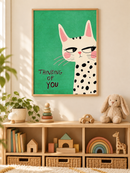 Thinking of You Kat in een houten lijst boven een speelgoedkast in een lichte kinderkamer